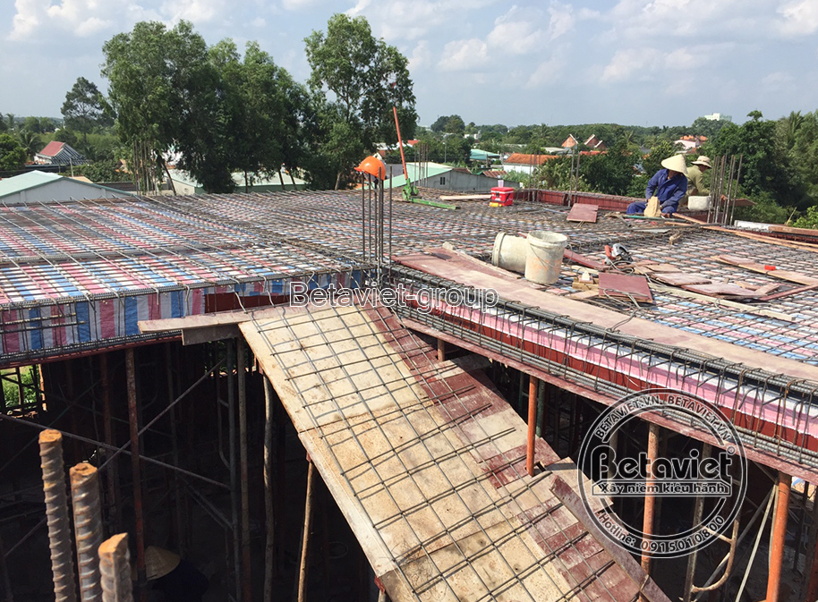 Cận cảnh một phần sàn tầng trên đang được bố trí cốt thép và cốp pha, nhìn từ góc chéo. Hệ thống cốt thép được đan xen chặ…