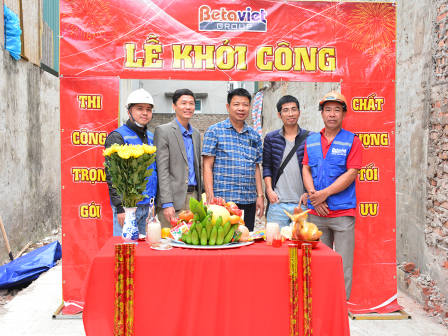 Toàn cảnh lễ khởi công dự án nhà phố, với đội ngũ Betaviet và gia chủ chụp ảnh lưu niệm. Cổng chào màu đỏ nổi bật với dòng…