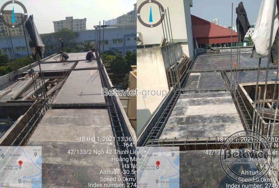 Sàn bê tông mái vừa đổ xong bề mặt còn ướt, một công nhân cúi kiểm tra gần mép sàn sát tường nhà bên cạnh. Ảnh có ghi định…