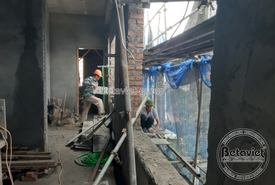 Ảnh ghép công nhân đội mũ bảo hộ leo khung ván gỗ trong giếng cầu thang; công nhân khác quỳ thao tác gần tấm bạt xanh, khô…