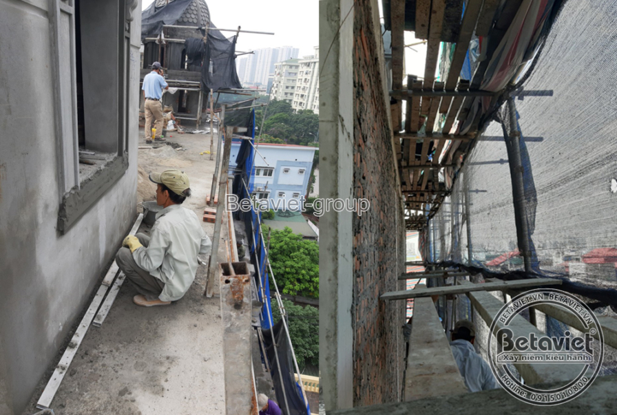 Công nhân ngồi trên bệ cửa sổ mặt tiền, phía trên là mái vòm tháp nhỏ đã lên hình, nhìn xuống toàn cảnh khu phố bên dưới…