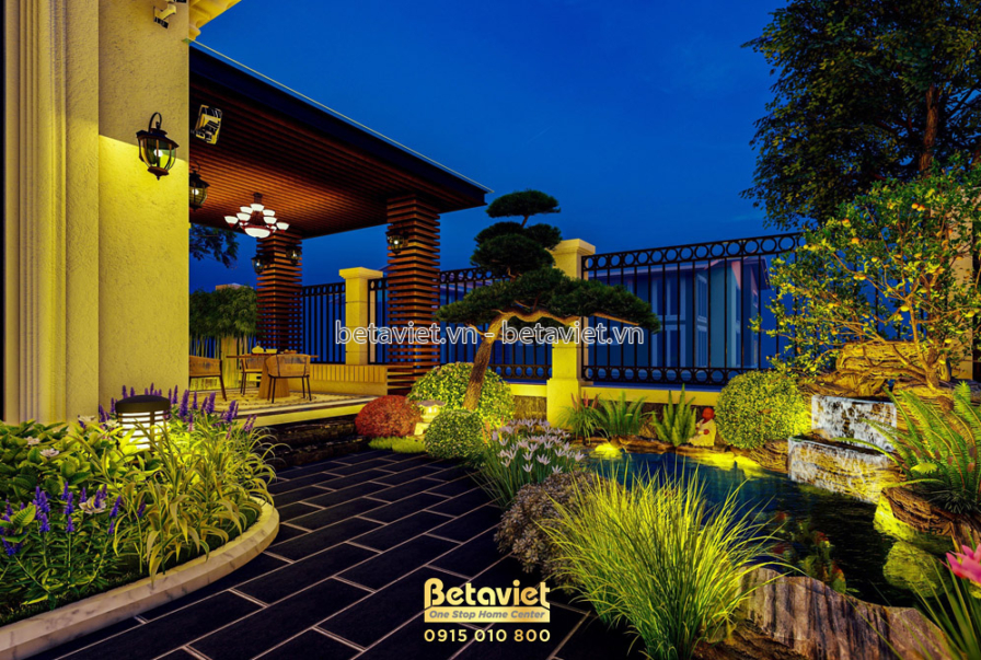 Chòi nghỉ ngoài trời với mái pergola gỗ tròn, cột gỗ nâu trầm, đèn lồng thả trần, phía trước là tiểu cảnh đá kết hợp thác…