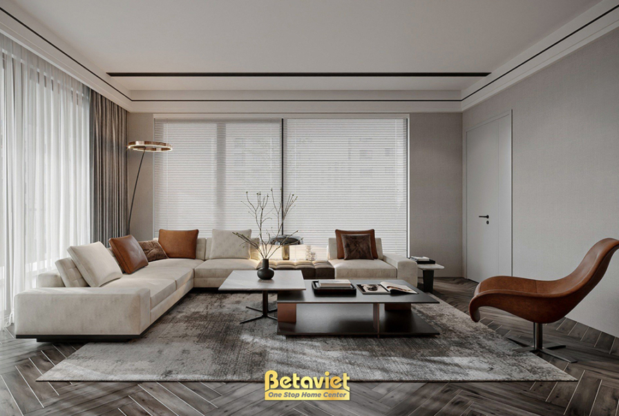 Phòng khách tối giản với cụm sofa kem đối xứng, bàn trà thấp, bình cành cây khô trang trí, cửa gỗ trắng, rèm sáo và rèm vo…