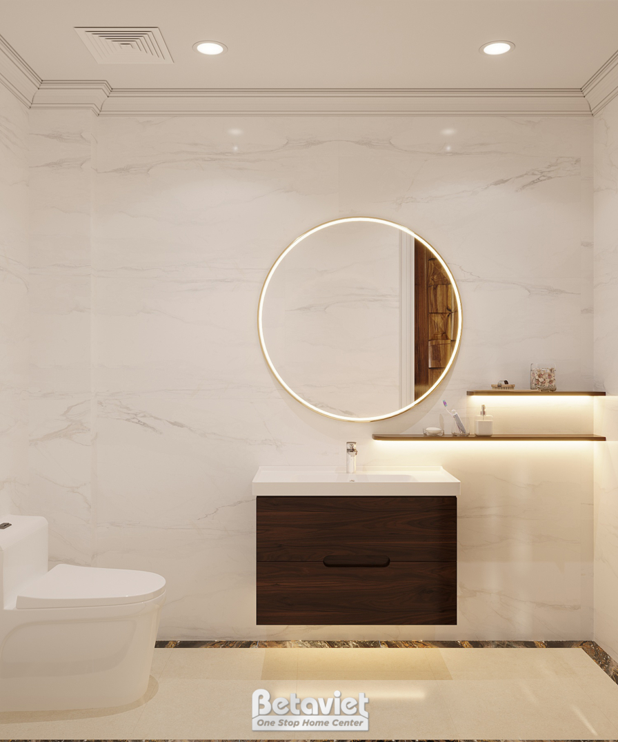 Phòng tắm với gương tròn viền vàng ánh kim, tủ lavabo gỗ óc chó đơn, kệ tường có đèn hắt, tường ốp đá marble trắng vân nhẹ…