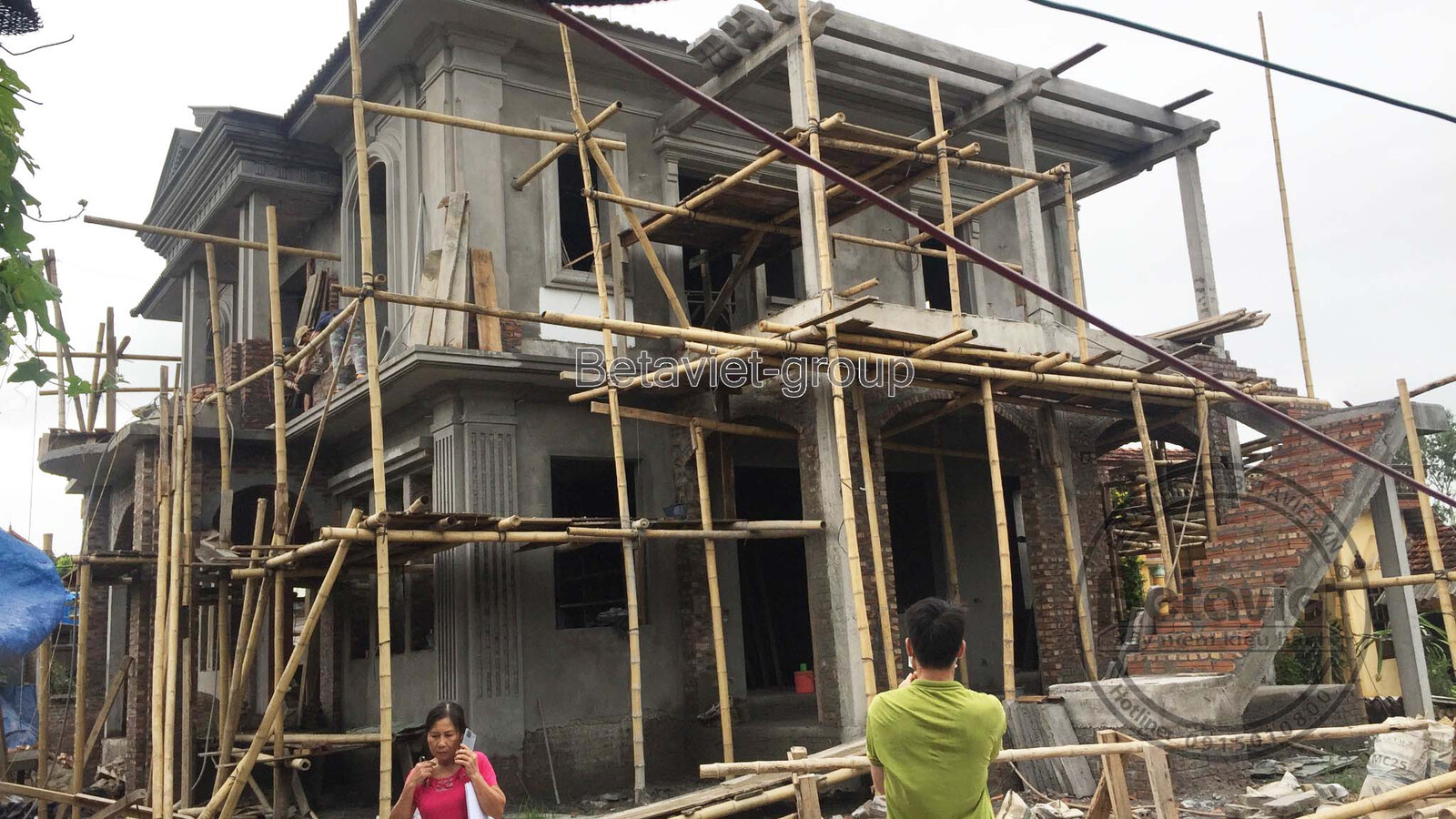 Biệt thự đang thi công phần thô, nhìn từ xa với giàn giáo bao phủ, cho thấy quy mô công trình và sự chuẩn bị kỹ lưỡng cho…