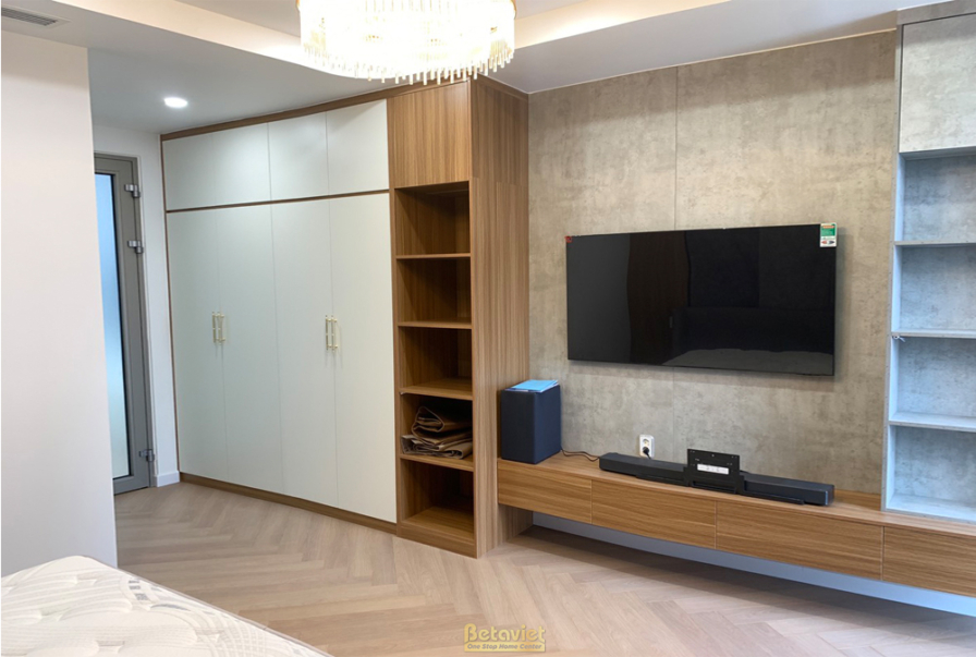 Phòng ngủ với tủ quần áo âm tường màu trắng và gỗ, kệ tivi treo tường. Sàn gỗ xương cá, thiết kế hiện đại, tối giản, tối ư…