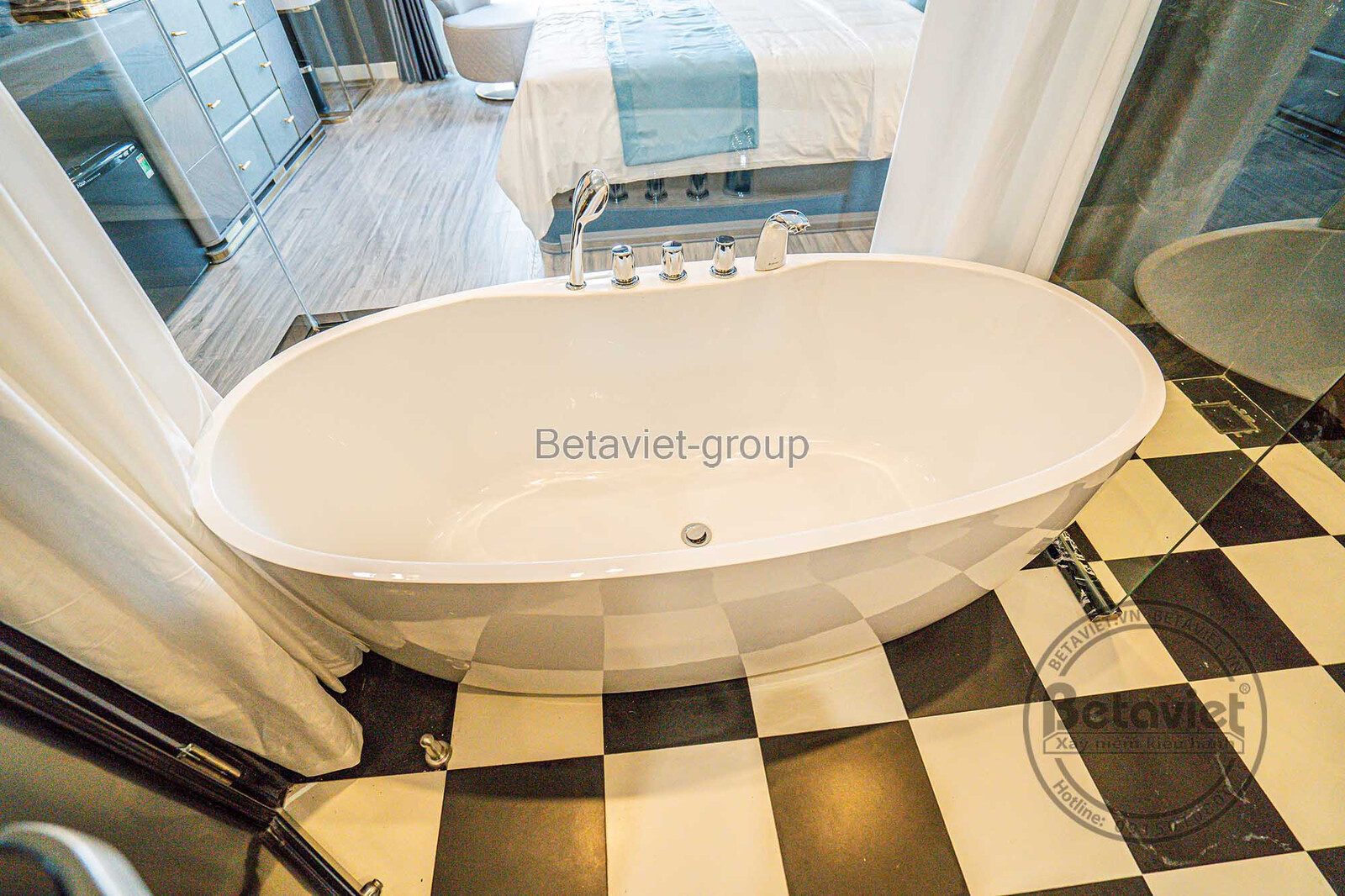 Phòng tắm sang trọng với bồn tắm độc lập hình oval màu trắng. Sàn nhà lát gạch caro đen trắng tạo điểm nhấn cổ điển, kết h…