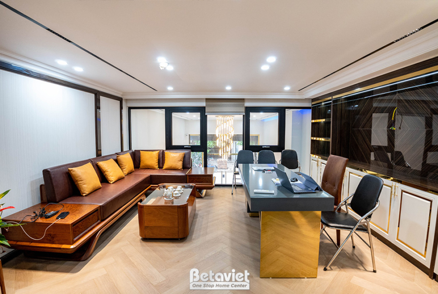 Phòng khách hoặc phòng sinh hoạt chung với sofa da chữ L màu nâu, bàn trà đá. Tường ốp gỗ và kính, sàn gỗ, tạo không gian…