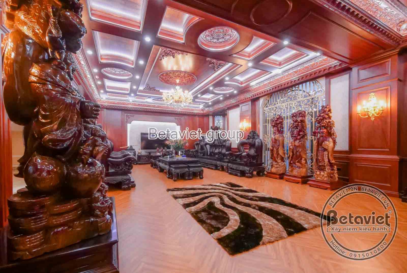 Góc nhìn cận cảnh bộ bàn ghế gỗ tự nhiên lớn trong phòng sinh hoạt chung, với các chi tiết chạm khắc tinh xảo. Thảm trải s…