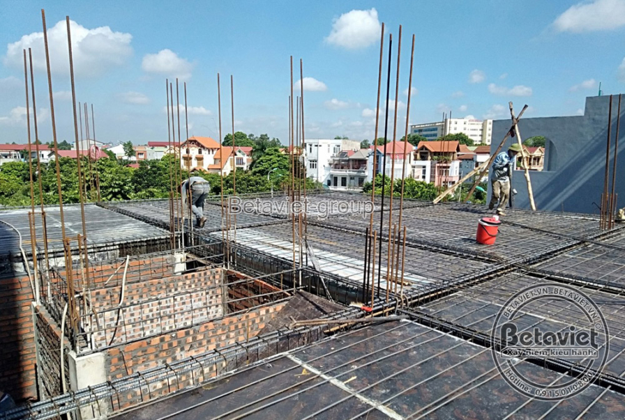 Góc nhìn từ trên cao xuống sàn bê tông cốt thép đang được chuẩn bị, với hệ thống cốt thép đan xen và cốp pha. Bố cục ảnh c…