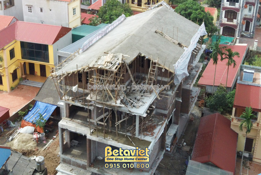 Toàn cảnh công trình nhà phố hiện đại 3 tầng đang thi công phần thô, nhìn từ trên cao xuống. Mái nhà tạm được che chắn bằn…