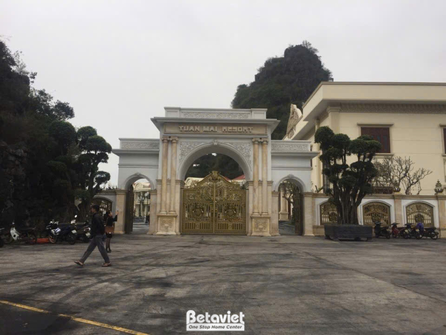 Cổng chào chính của resort Tuấn Mai vào ban ngày, nhìn từ bên trong ra ngoài. Cổng vòm lớn với kiến trúc tân cổ điển, tườn…