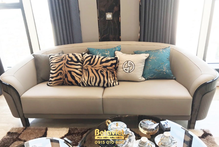 Cận cảnh bộ sofa chính với chất liệu da màu be cao cấp, được trang trí bằng những chiếc gối tựa họa tiết da báo, màu xanh…