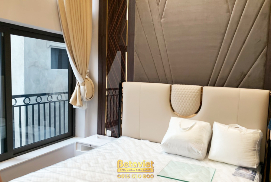 Góc nhìn tổng thể phòng ngủ, nổi bật là giường ngủ bọc nệm cao cấp với đầu giường thiết kế tinh xảo. Phía sau là vách ốp t…