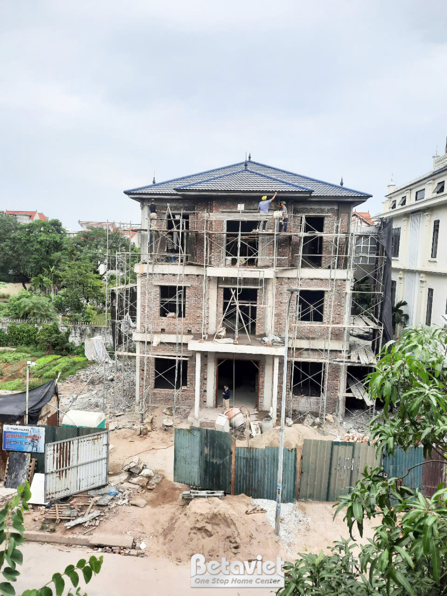 Toàn cảnh ngôi nhà phố 3 tầng đang thi công phần thô, nhìn từ phía trước. Các bức tường gạch đã xây xong, khung cửa sổ đã…