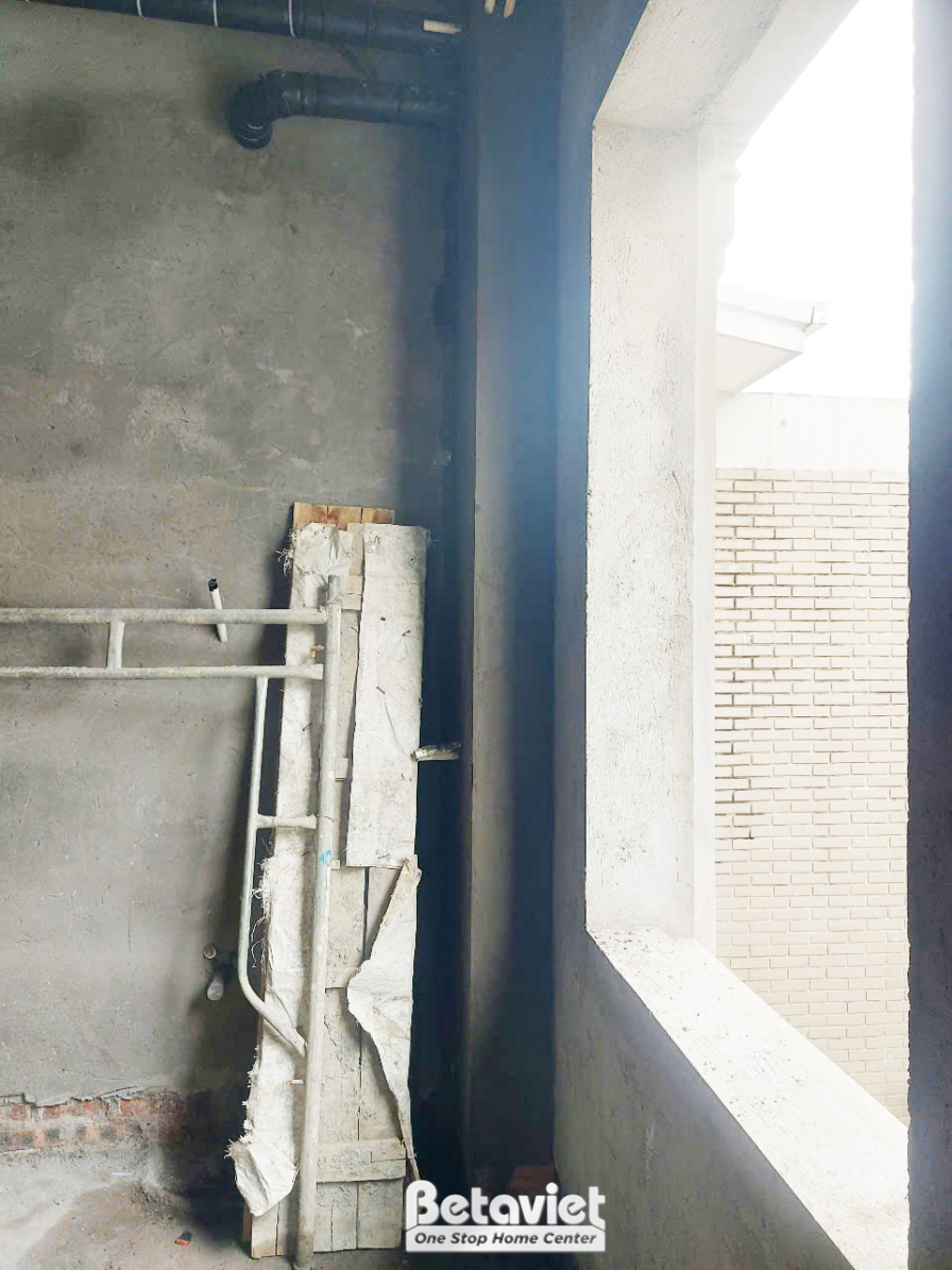 Cận cảnh khung cửa sổ đang được lắp đặt vào bức tường gạch trong giai đoạn thi công phần thô. Các chi tiết khung cửa được…