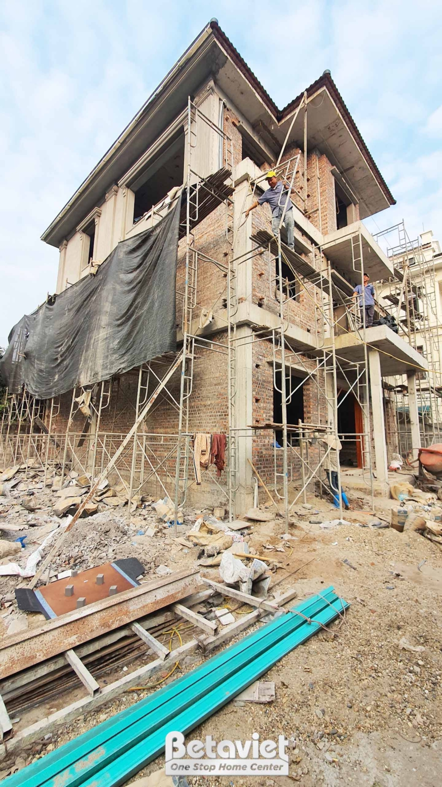 Góc nhìn từ dưới lên của ngôi nhà phố 3 tầng đang thi công phần thô. Các cột bê tông và dầm sàn đã được đổ, tường gạch đan…