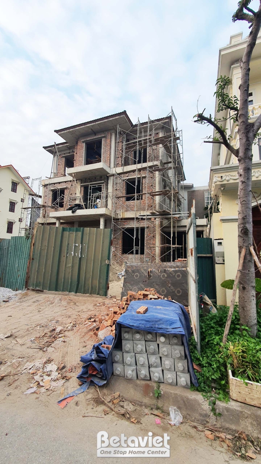 Góc nhìn từ dưới lên của ngôi nhà phố 3 tầng đang thi công phần thô. Các cột bê tông và dầm sàn đã được đổ, tường gạch đan…