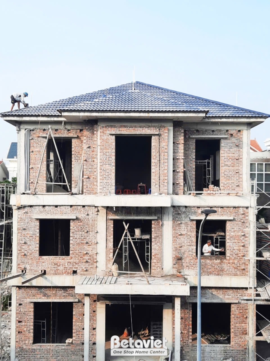 Ngôi nhà phố 3 tầng đang trong giai đoạn thi công phần thô, nhìn từ phía trước. Các bức tường gạch đã xây xong, khung cửa…