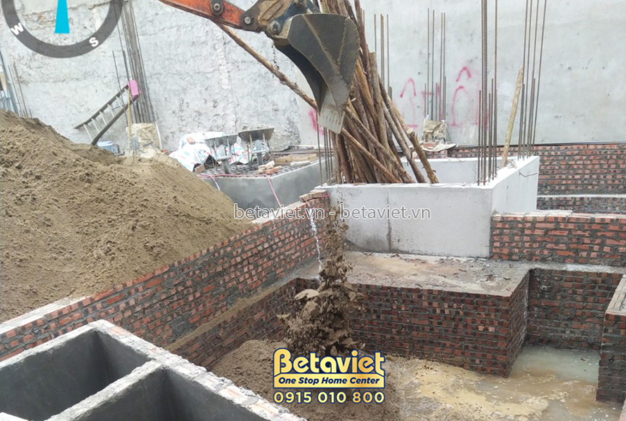 Công nhân đang xây tường gạch cho tầng 1, sau khi đã đổ móng. Gạch và cát được tập kết tại công trường. Ánh sáng ban ngày…