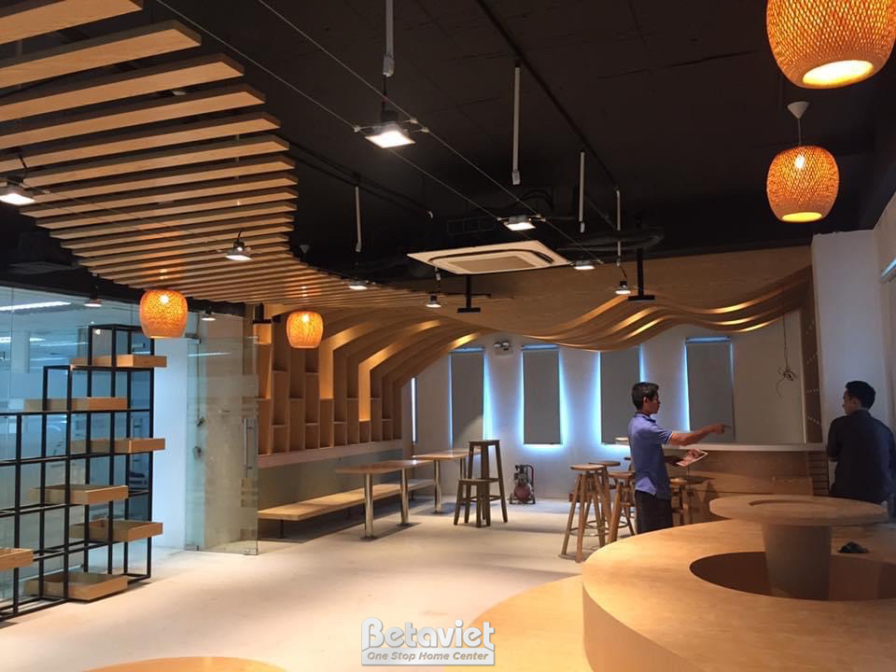 Khu vực ngồi bên trong quán cafe với bàn ghế gỗ đơn giản, hiện đại. Trần lam gỗ sóng tạo điểm nhấn thị giác, kết hợp đèn t…