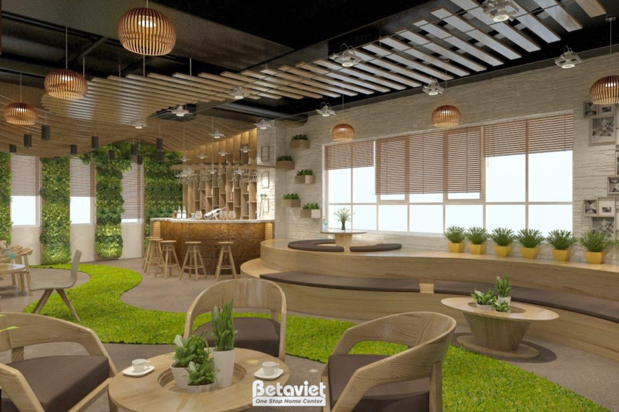 Góc nhìn tổng thể không gian quán cafe với sự kết hợp hài hòa giữa nội thất gỗ, thảm cỏ nhân tạo và cây xanh. Trần lam gỗ…
