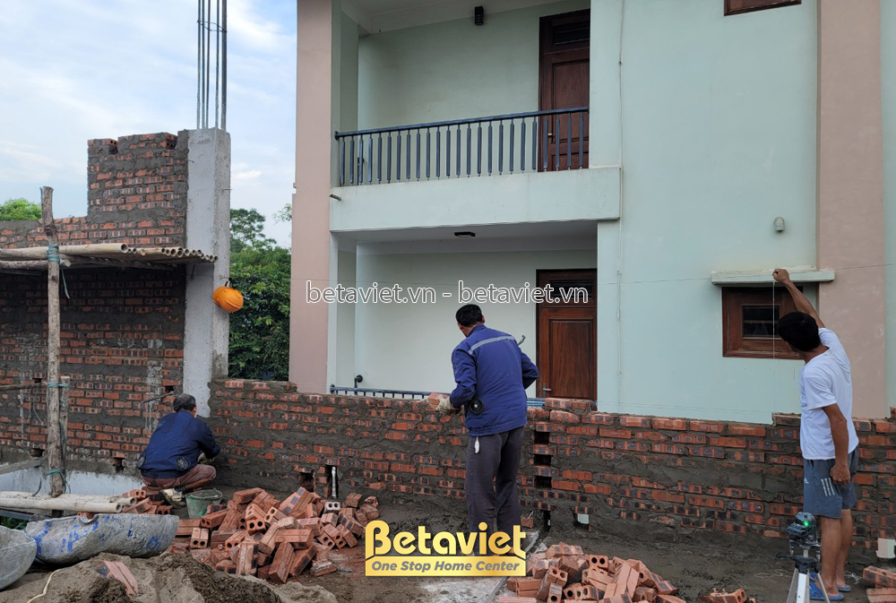 Cận cảnh một phần tường gạch đỏ đang được xây dựng bởi công nhân. Bức tường được xây thẳng hàng, mạch vữa đều, cho thấy sự…