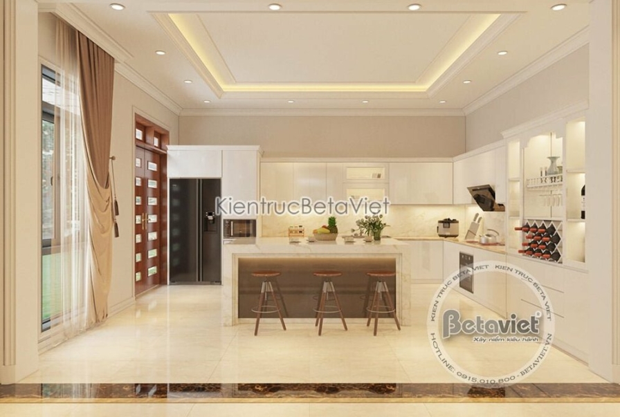 Phòng bếp biệt thự Art Deco NT19320 — tủ bếp chữ U tông trắng bóng, mặt đảo đá marble và tay nắm đồng thau đặc trưng