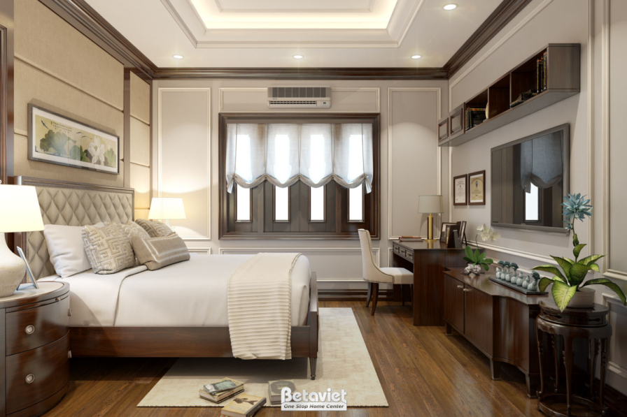Phòng ngủ đầu giường bọc nệm màu be, bàn làm việc gỗ kèm ghế bọc nệm, cửa sổ rèm voan trắng, thảm trải sàn gỗ, tường ốp ph…