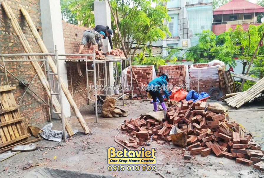 Công nhân đang xây tường gạch cho tầng 2 của công trình. Gạch và vữa được vận chuyển bằng xe rùa. Giàn giáo được dựng chắc…