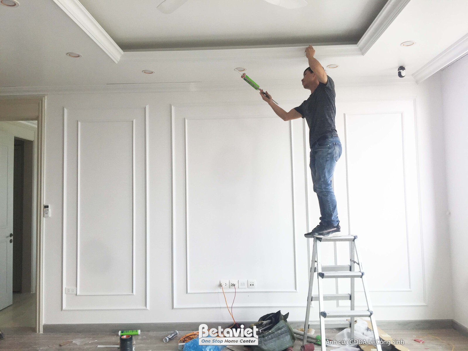 Toàn cảnh không gian phòng khách và khu vực ăn uống nhìn từ cửa ra vào, đang trong giai đoạn hoàn thiện. Các vật liệu xây…