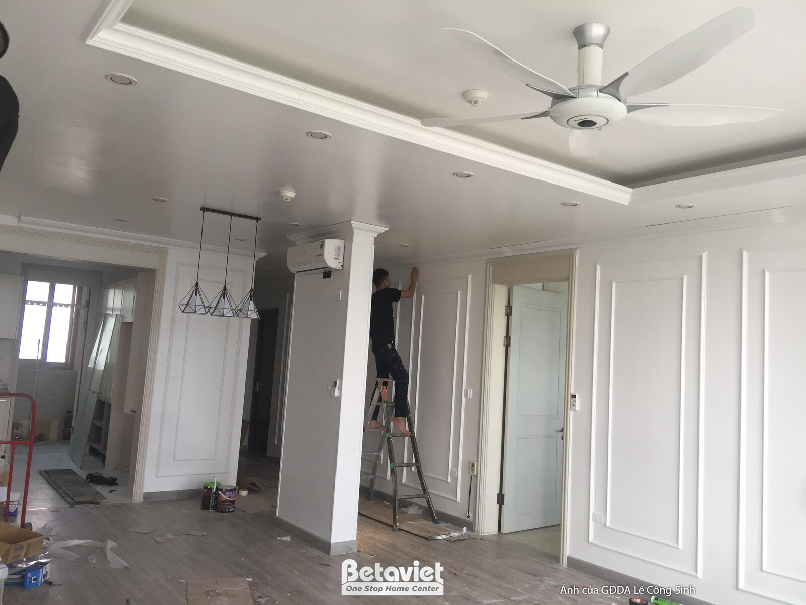 Góc nhìn tổng thể không gian phòng khách và khu vực ăn uống đang trong giai đoạn hoàn thiện. Trần thạch cao phẳng với đèn…