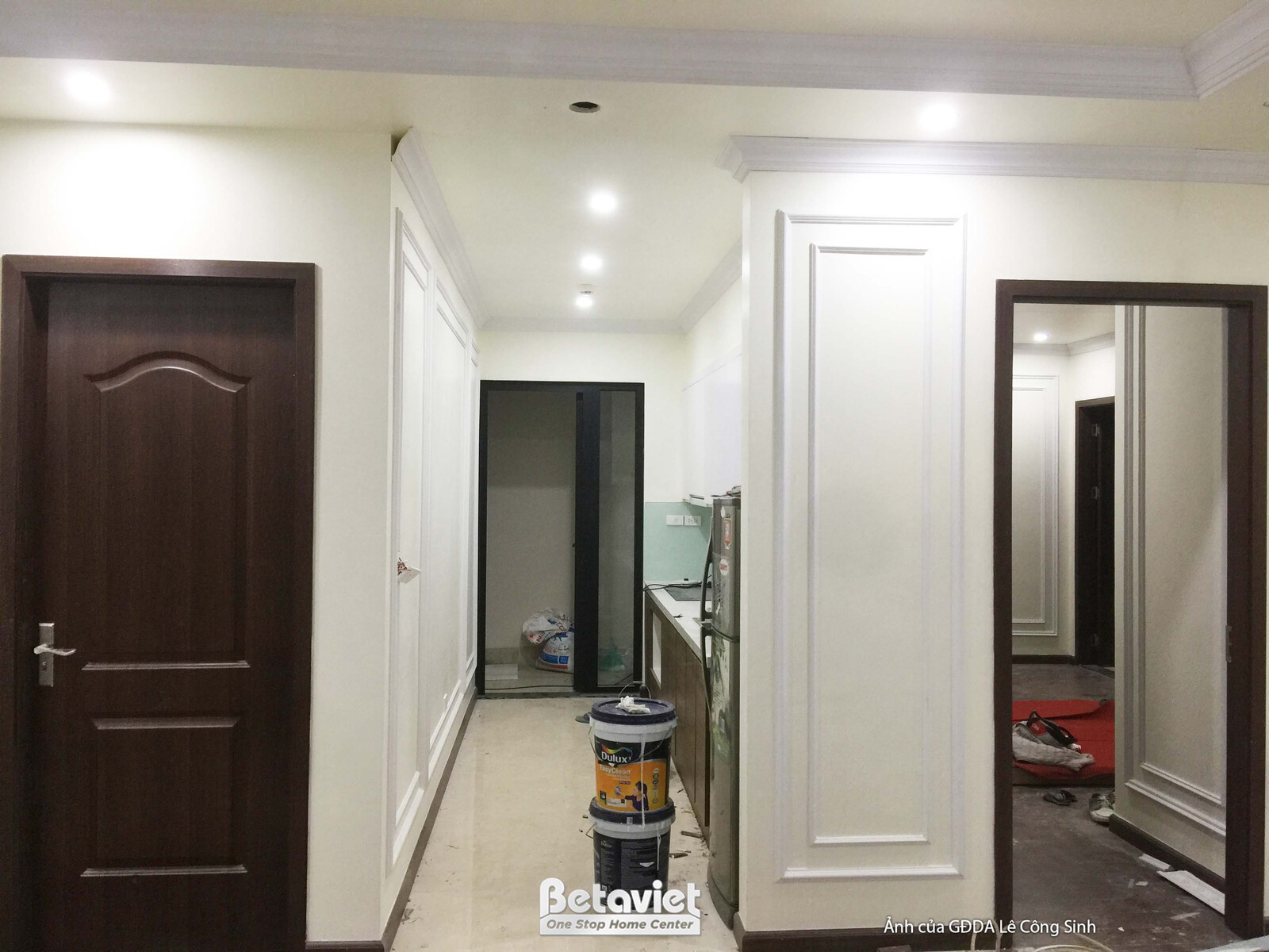 Góc không gian với tủ âm tường màu trắng tích hợp gương soi, mang lại sự tiện nghi và mở rộng không gian. Cửa gỗ màu nâu đ…