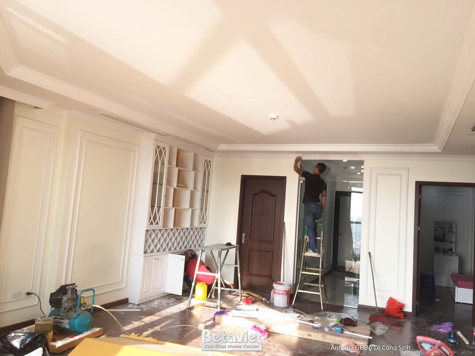 Không gian phòng khách rộng rãi đang trong giai đoạn hoàn thiện, với sàn gỗ ấm áp và tường ốp phào chỉ màu trắng sang trọn…