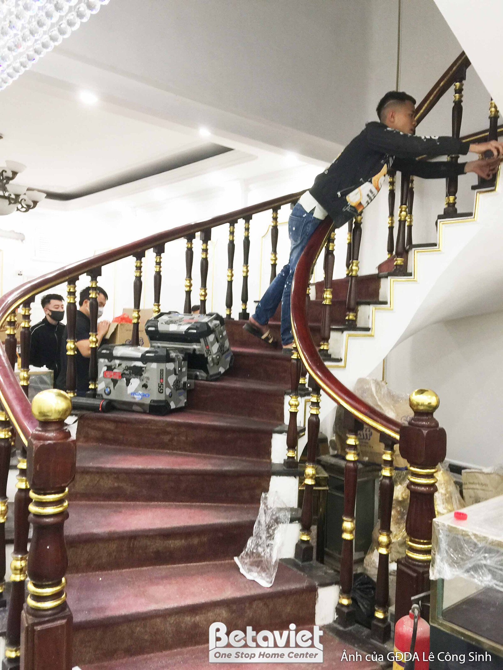 Cầu thang uốn lượn phong cách cổ điển đang được thi công hoàn thiện. Bậc thang và tay vịn gỗ tự nhiên màu nâu đỏ, lan can…