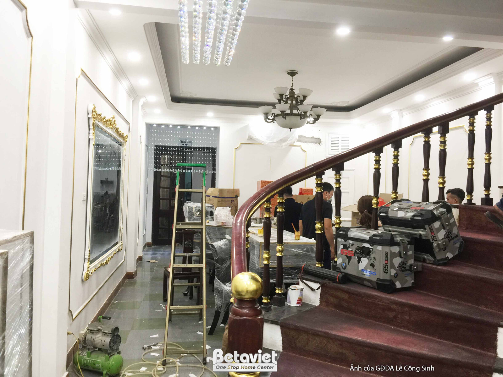 Góc nhìn tổng thể khu vực sảnh và cầu thang chính của cửa hàng. Cầu thang gỗ uốn cong với lan can cổ điển là điểm nhấn tru…