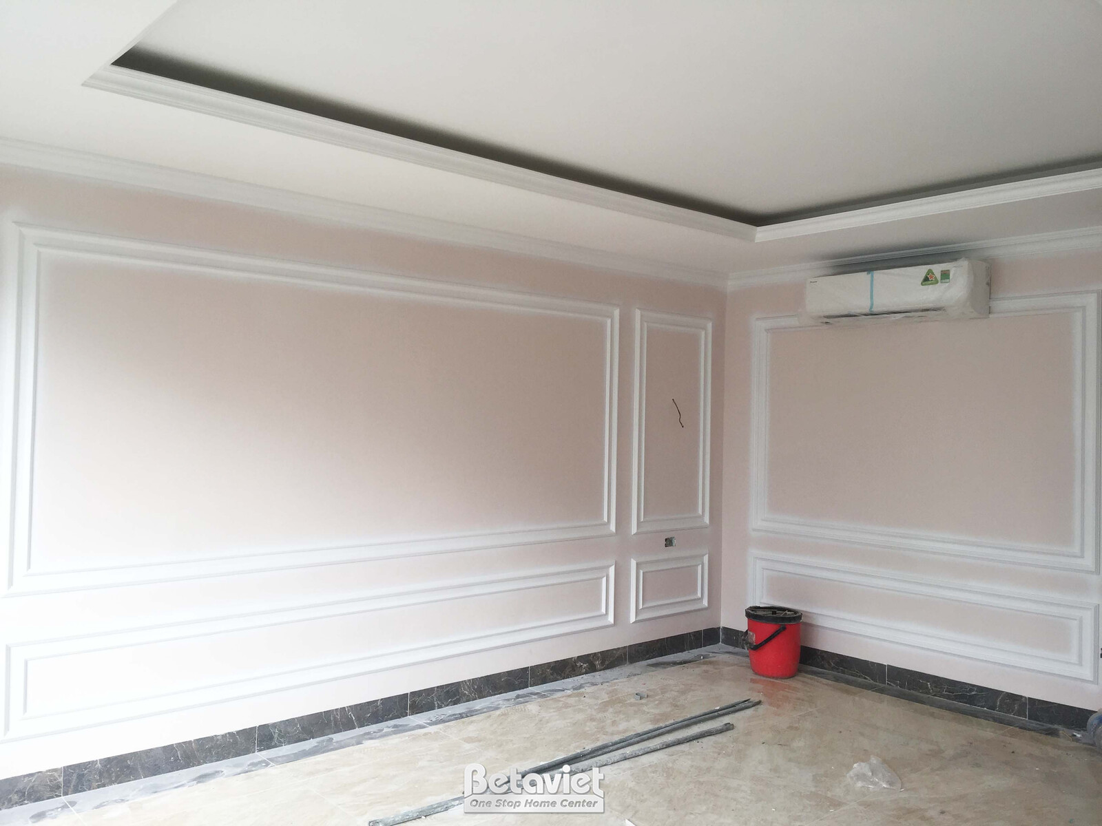 Phòng ngủ rộng rãi đang trong giai đoạn hoàn thiện nội thất. Tường được sơn màu hồng nhạt và trang trí phào chỉ tân cổ điể…