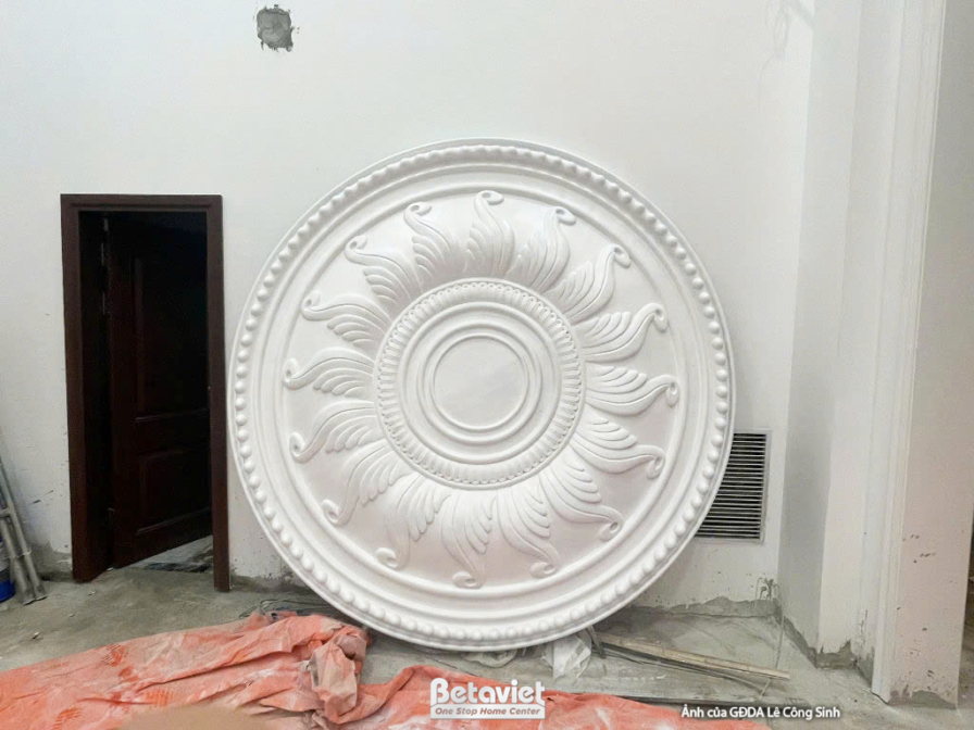 Cận cảnh một phù điêu tròn lớn bằng thạch cao hoặc vật liệu tương tự, với các họa tiết chạm khắc tinh xảo theo phong cách…