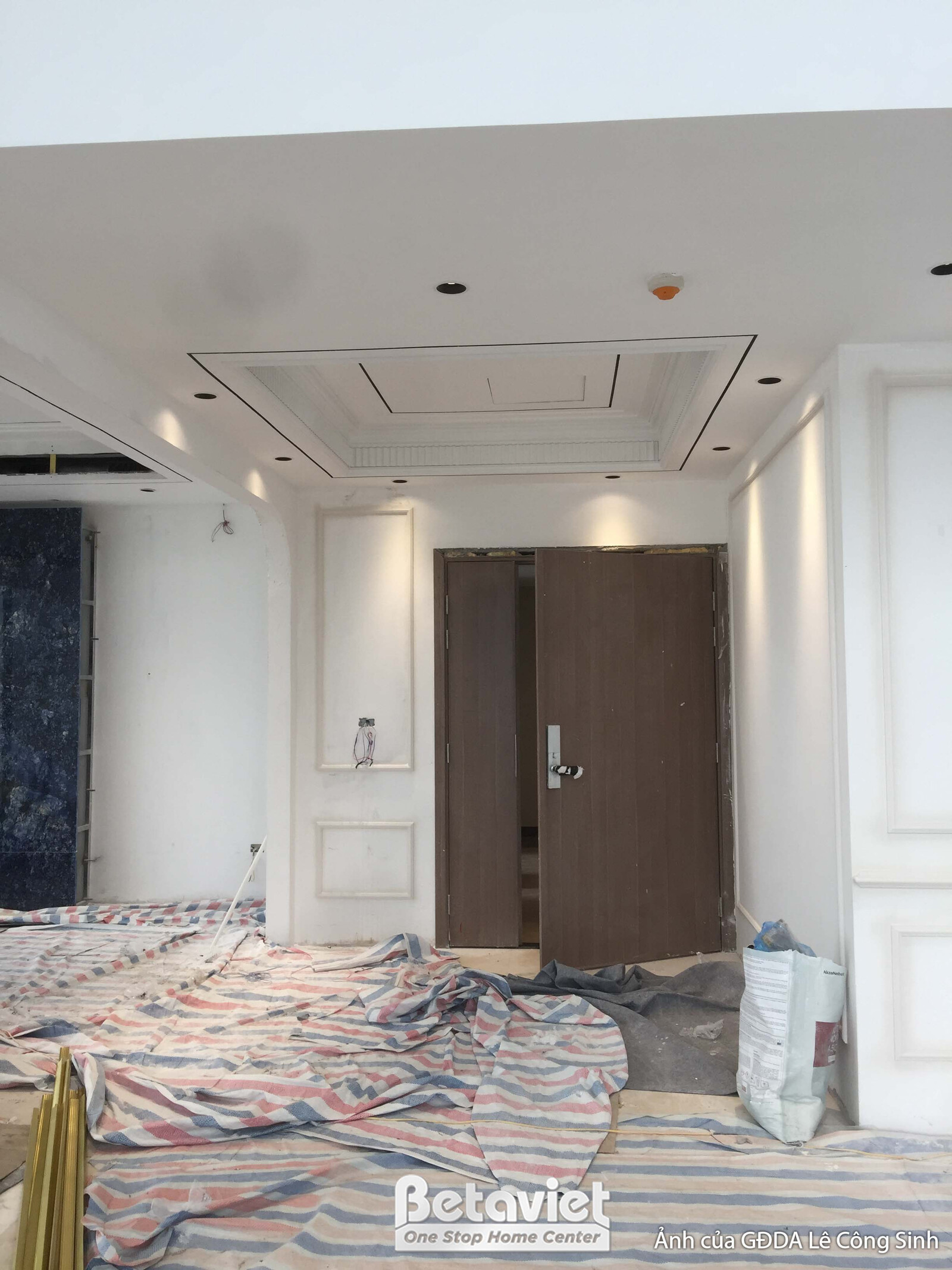 Lối vào căn hộ với cửa chính và trần thạch cao giật cấp. Không gian đang trong quá trình hoàn thiện, với các vật liệu bảo…