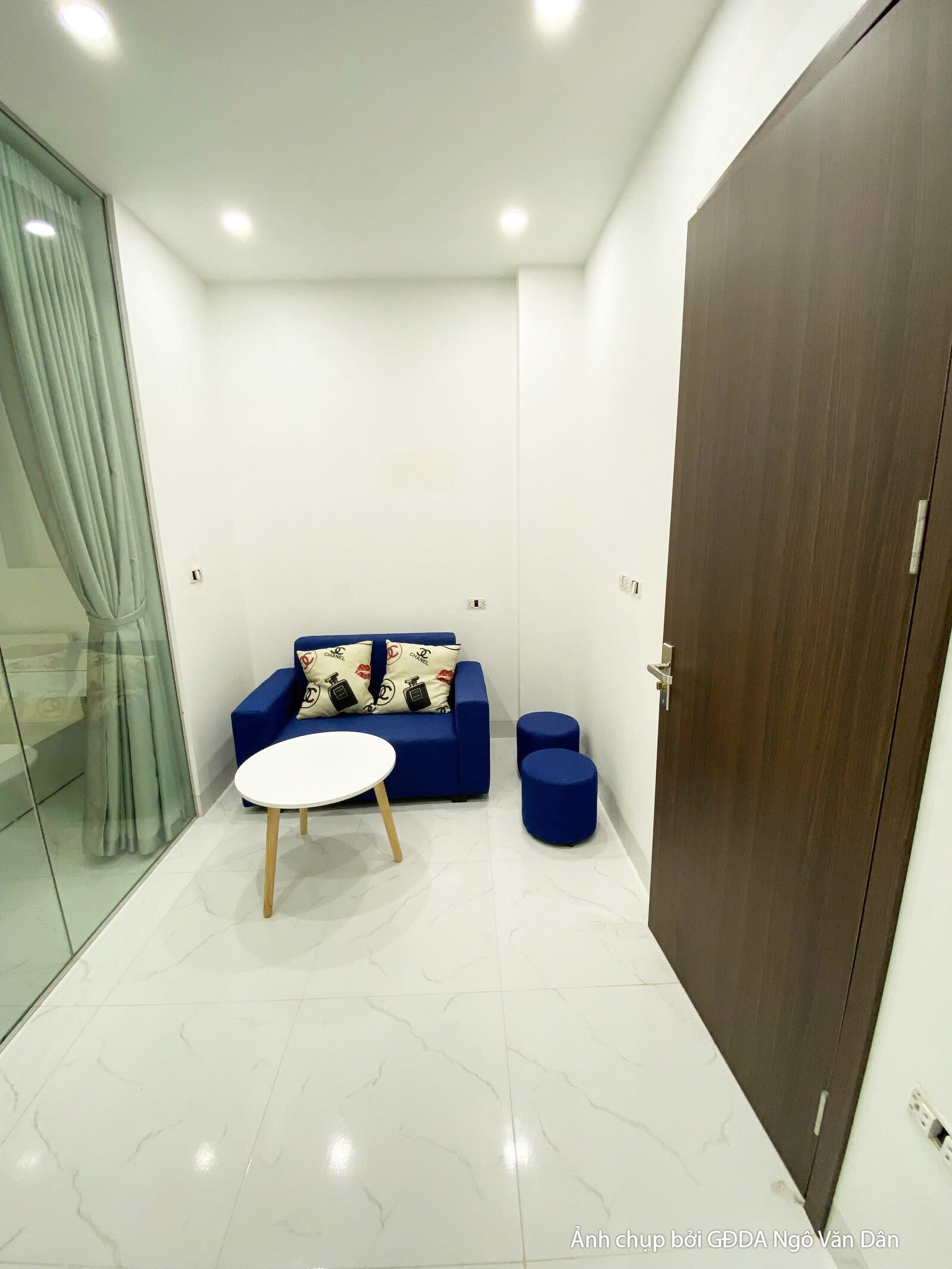 Hành lang hoặc lối vào căn hộ đã hoàn thiện, với cửa gỗ công nghiệp màu nâu trầm và sàn gạch men sáng màu. Bố cục thẳng, t…