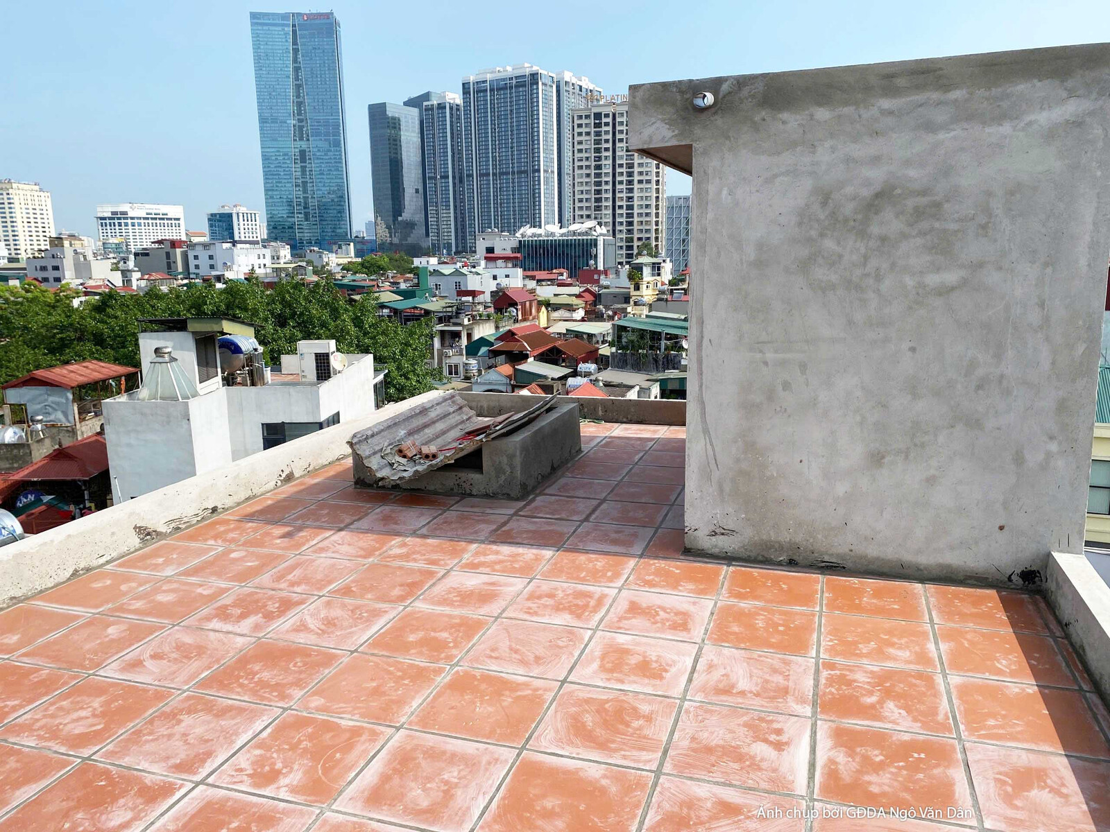 Sân thượng đã được lát gạch đỏ truyền thống, có một bồn cây hoặc ghế bê tông tạo điểm nhấn. Bố cục rộng, nhìn ra cảnh quan…