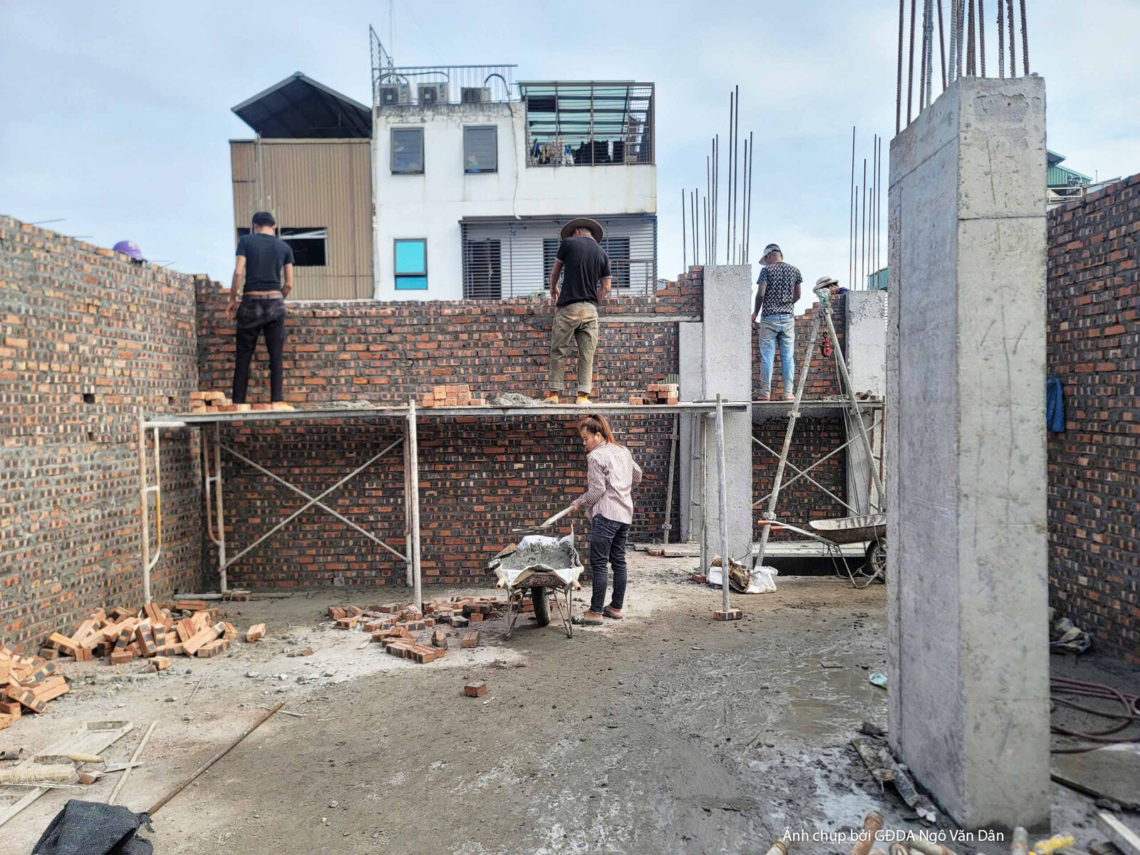 Không gian ngoại thất của công trình nhà phố đang trong giai đoạn xây tường gạch. Bố cục từ góc thấp cho thấy các bức tườn…