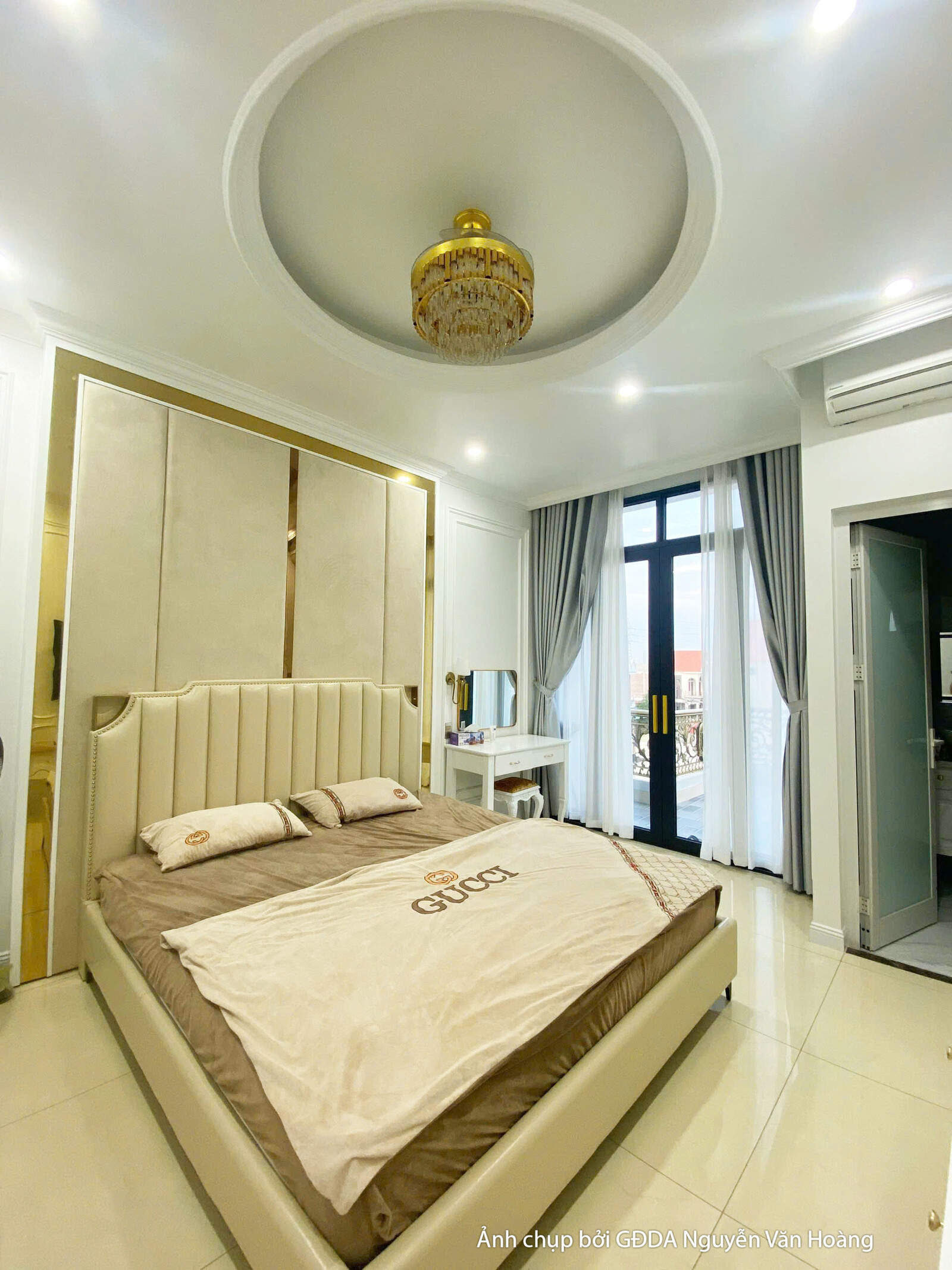 Phòng ngủ đã hoàn thiện với giường lớn, vách đầu giường được ốp gỗ và trang trí phào chỉ vàng kim, tạo điểm nhấn sang trọn…