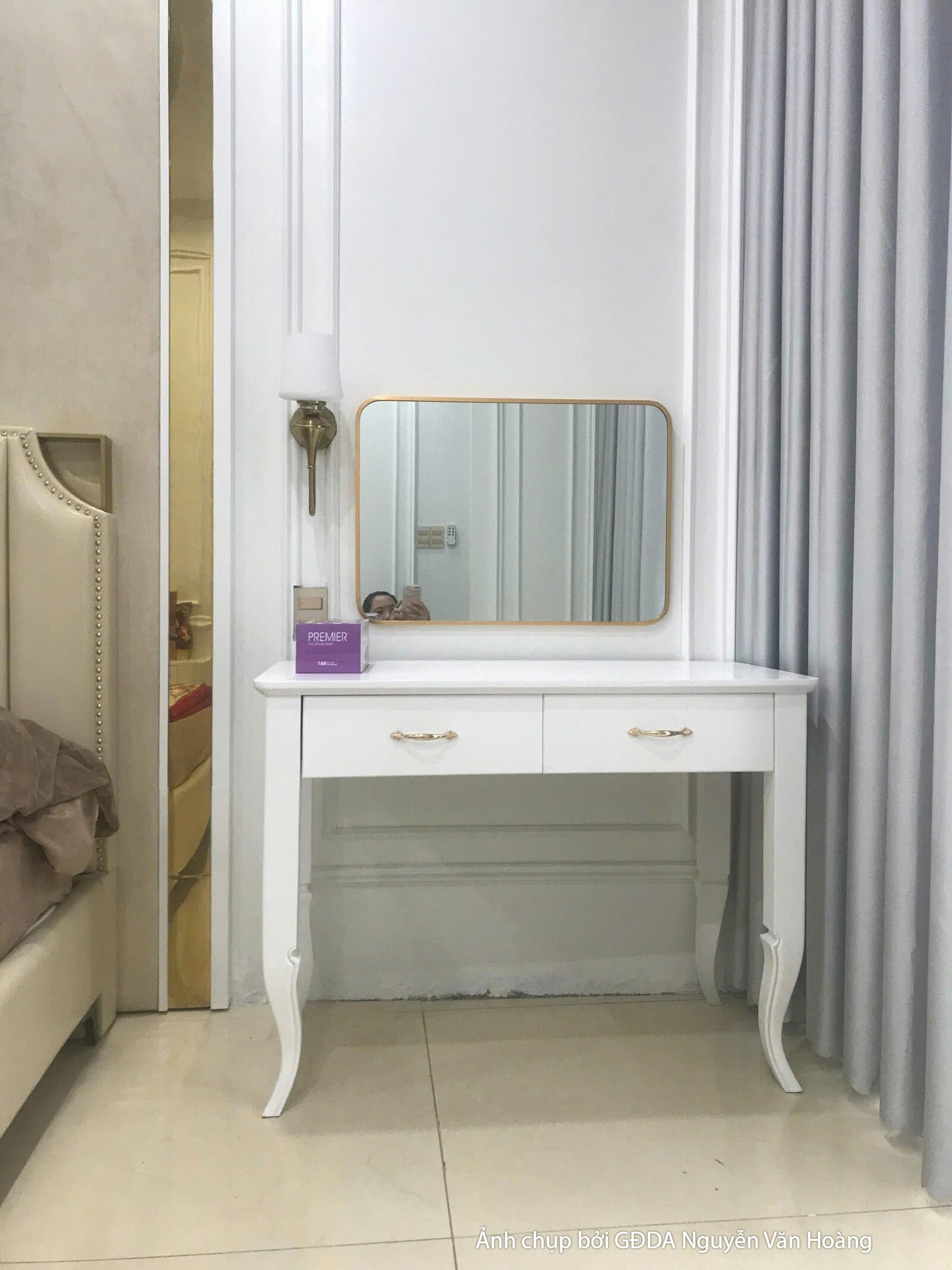Cận cảnh bàn trang điểm màu trắng tinh tế, kết hợp gương tròn viền vàng và ghế đôn bọc nệm. Đây là một góc nhỏ tiện ích và…