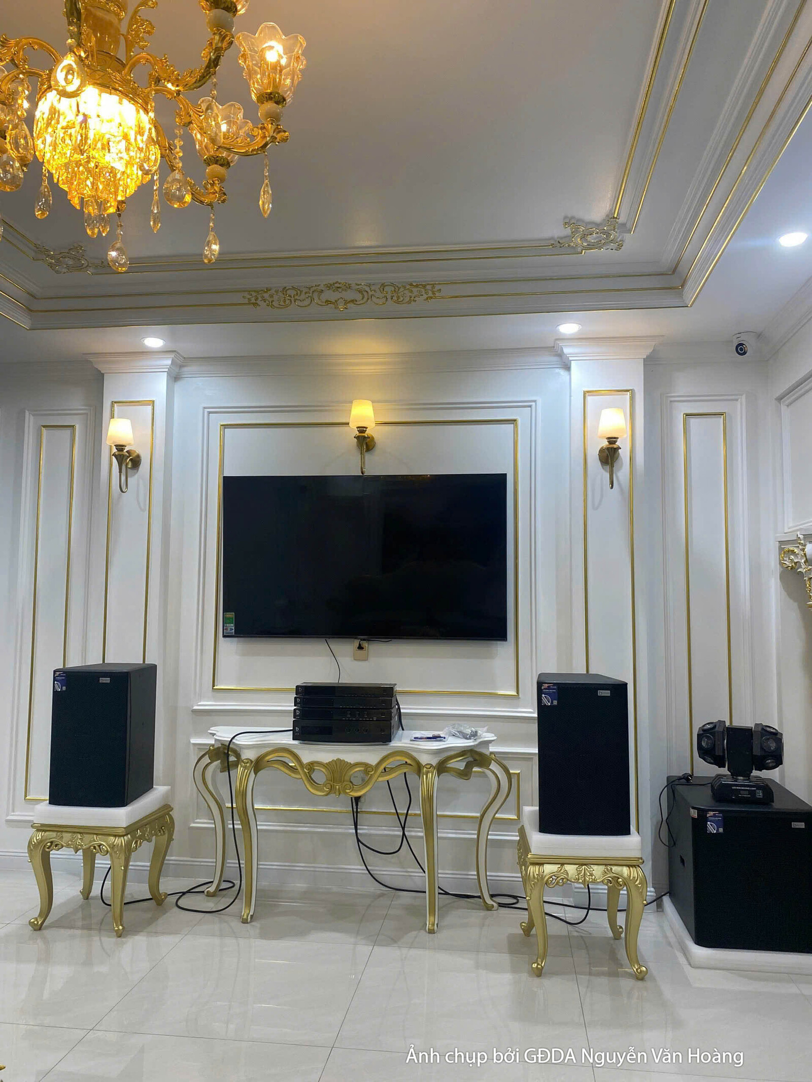 Góc nhìn từ trên xuống của phòng khách đã hoàn thiện, cho thấy sự bề thế của không gian thông tầng. Đèn chùm pha lê lộng l…