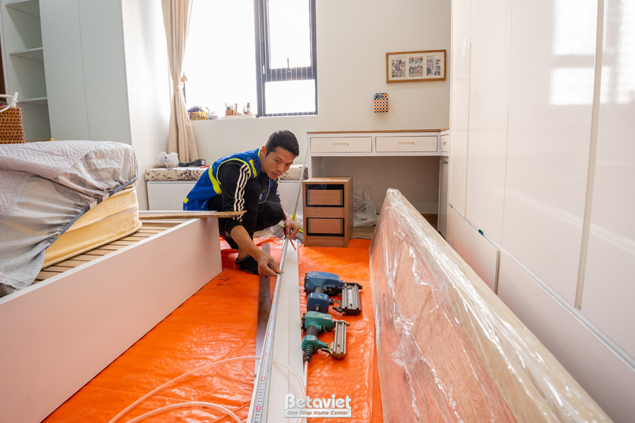 Khu vực phòng ngủ hoặc phòng làm việc đang được lắp đặt nội thất. Một thành viên đội ngũ Betaviet đang lắp ráp khung giườn…