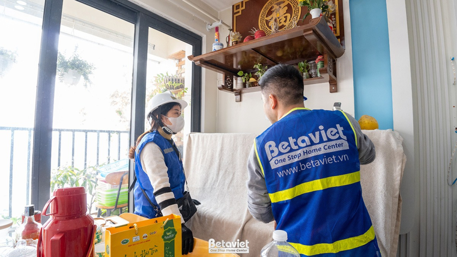 Góc nhìn ra ban công từ khu vực phòng khách hoặc bếp. Một thành viên đội ngũ Betaviet đang kiểm tra khu vực cửa kính lớn…