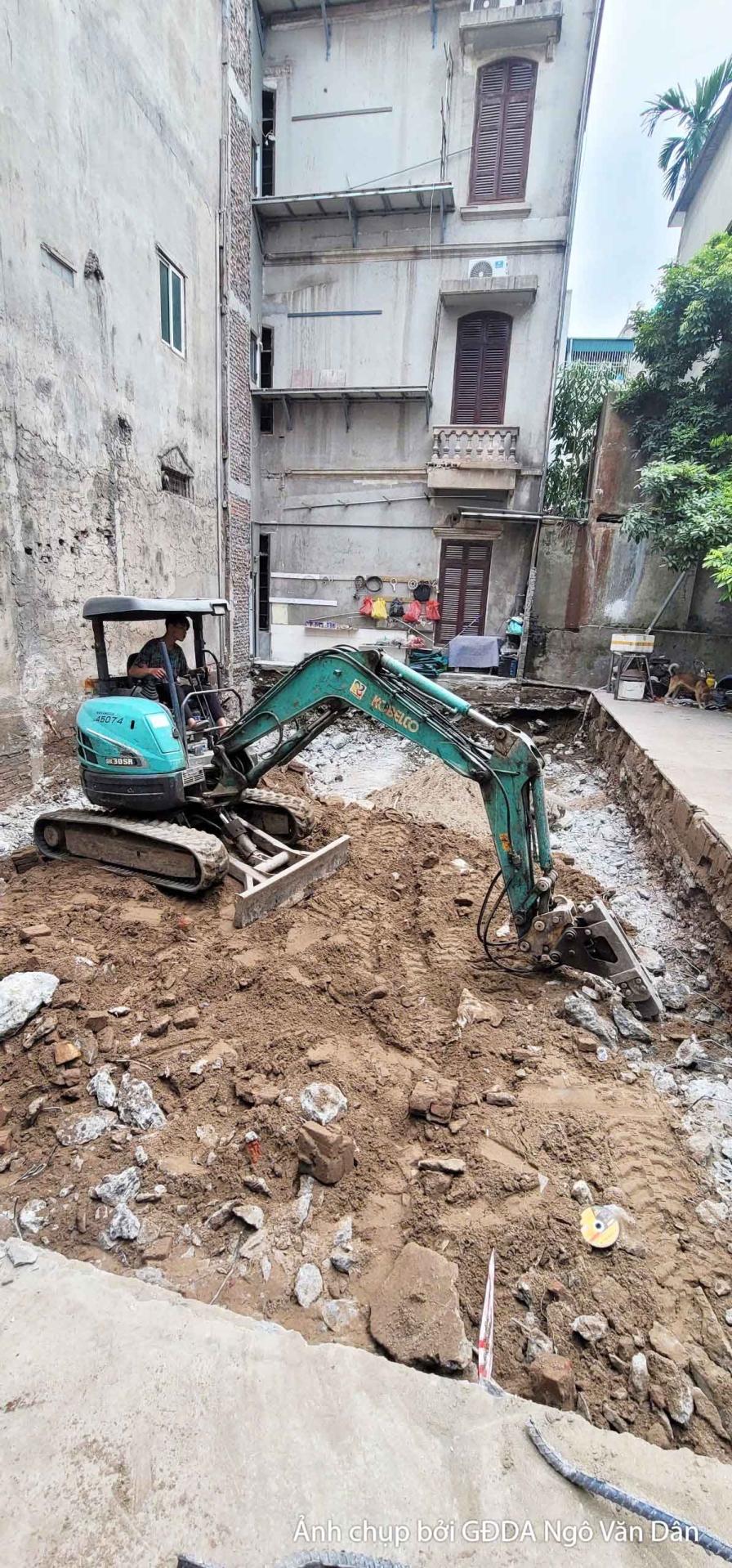 Hình ảnh máy xúc đang hoạt động tại công trường, thực hiện công tác đào móng hoặc san lấp mặt bằng. Đất đá được di chuyển…