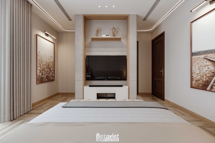Phòng ngủ với cột ốp đá marble bao quanh vách tivi tạo điểm nhấn kiến trúc, giường bọc nệm trắng, hai bức tranh treo đối x…