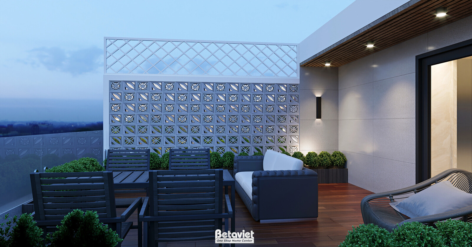 Góc khác sân chơi với vách lưới hoa văn trang trí, ghế sofa ngoài trời, bàn ghế sắt đen. View thành phố phía xa lúc chiều…